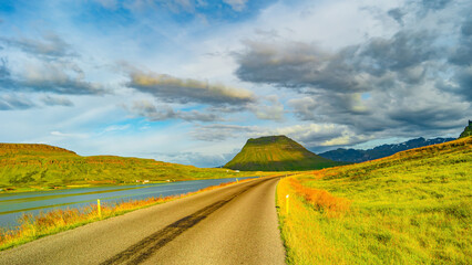 Panorama with a paved road, Ring road, through rough and colorful Icelandic landscape, Iceland, summer, suny blue sky