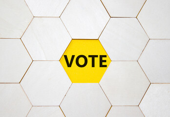 Vote symbol. Concept word Vote on wooden comb puzzle. Beautiful yellow background. Business and...