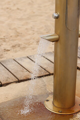 Beach shower, close-up. Summer vacation concept. Beach shower by the sea or river. Arrangement of the beach area for the convenience of vacationers. Shower for washing feet from sand