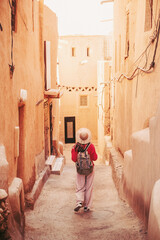 Female tourist exploring ancient Moroccan architecture, enjoying the unique atmosphere of a traditional village