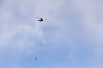 Helicopter Delivering Water to Forest Fire in Squamish, BC, Canada Clearing the Sky