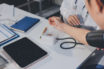 Doctor checking patient arterial blood pressure in hospital. Health care Concept