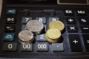 Business. Stacks of coins lie on the keyboard of the calculator