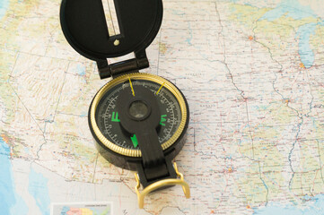 Army compass lies on an old physical map