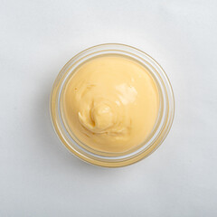 A delicious batch of creamy homemade mayonnaise sits in a clear glass jar, ready for use