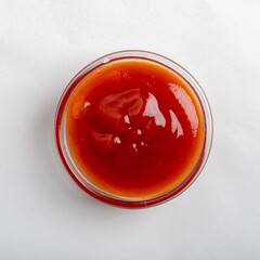 A vibrant red sauce sits in a glass bowl, inviting exploration of flavors and culinary delights
