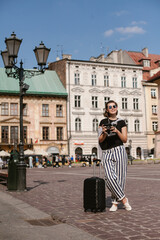 Tourist holding vintage camera exploring warsaw old town square