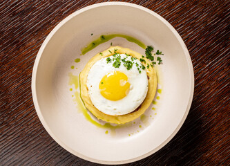 Enjoy a sunny-side-up egg on creamy polenta, topped with fresh herbs