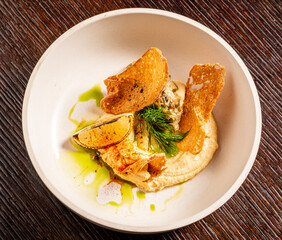 Crispy chips atop silky dip, garnished with lime and herbs for a creative touch