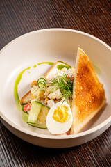 Toasted bread with a rich filling, topped with greens and a perfectly cooked egg