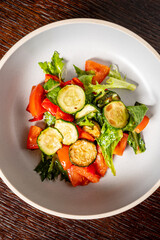 A vibrant salad with crisp lettuce, bright bell peppers, and fresh cucumbers in a bowl