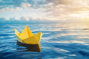 A tiny yellow paper boat floats gently on a calm blue sea under a vibrant sunset sky