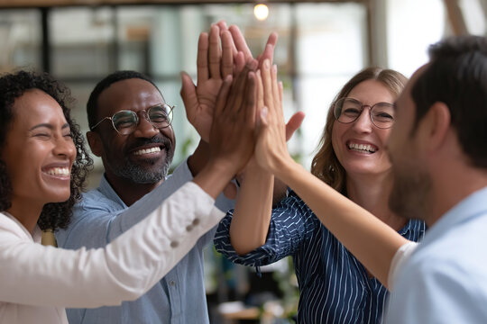 Diverse professionals celebrate teamwork and success in a modern office environment