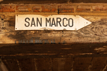 Directional sign to San Marco square on old Venetian building in Cannaregio neighborhood of Venice, Italy
