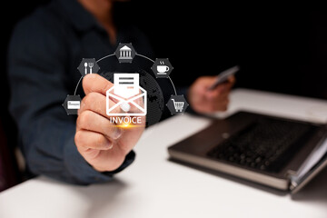 A person interacts with a virtual interface displaying an invoice icon and related business symbols over a laptop.