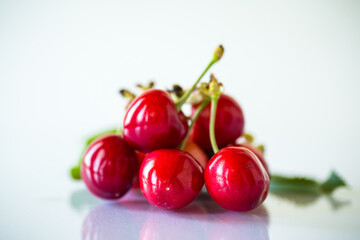 harvest of sweet red cherries on white background
