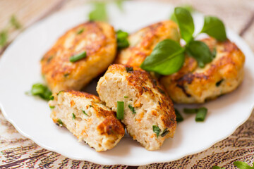cooked chicken cutlets with herbs on a wooden table