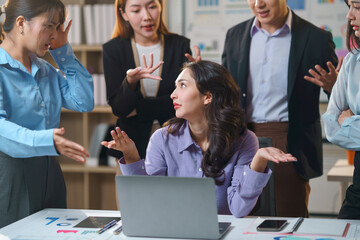 Asian businesspeople arguing during a stressful meeting in the office, blaming each other for bad...