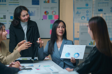 Asian businesswomen having a meeting presenting financial chart graphs analyzing company's performance