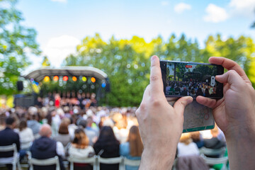 Person Filming an Outdoor Concert  with a Smartphone