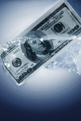 Money launderin. US Dollar sinking in water. Closeup. Vertical image. Copy space.