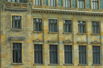 Fototapeta premium The impressive facade of the majestic stone building features elegant windows and intricate details, capturing the essence of urban design and showcasing its historic charm