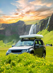 Magical landscape with a car on the background of a waterfall Seljalandsfoss in Iceland. Exotic countries. Amazing places. Popular tourist atraction.