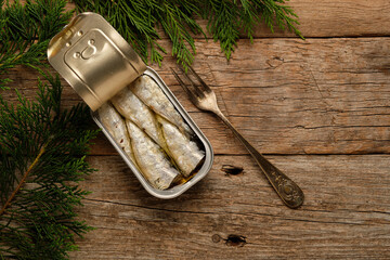 Sardines in Tin on Rustic Wooden Table Surrounded by Greenery