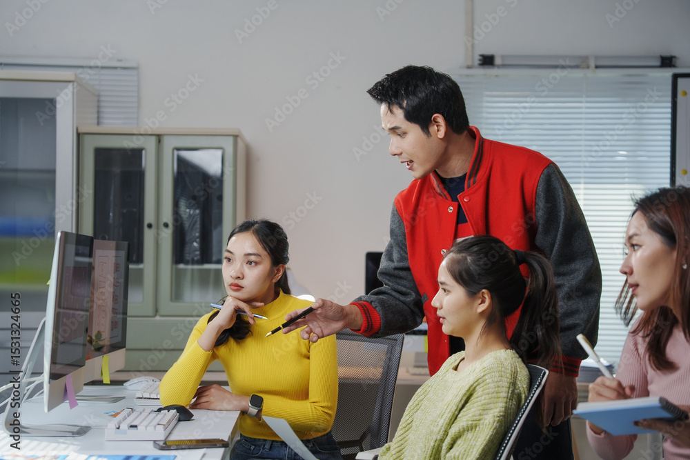 Poster young asian entrepreneurs having a discussion about a project, analyzing data on desktop computer in