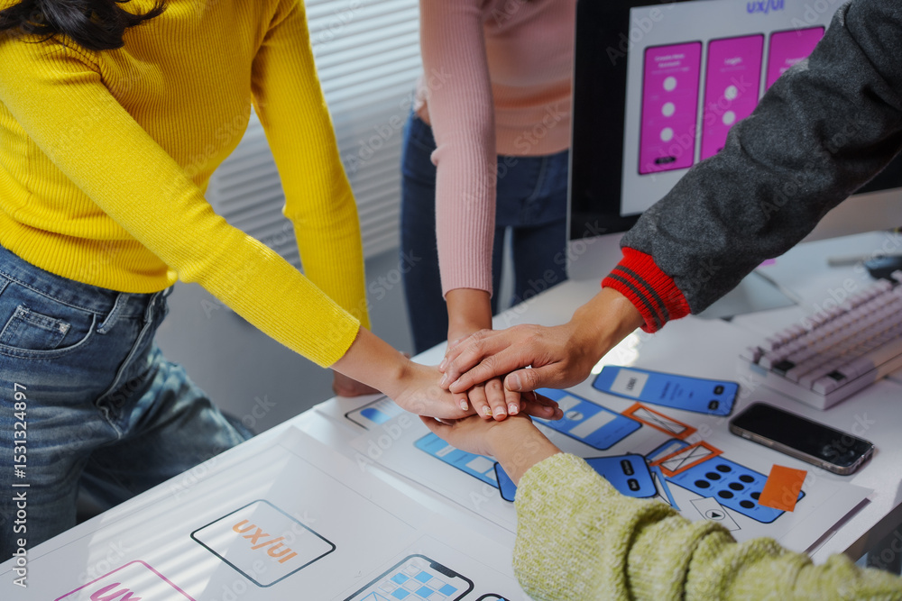 Aufkleber four uxui designers joining hands over a table, showing teamwork and collaboration in a software dev