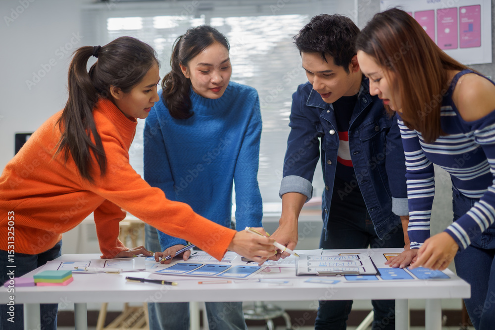Poster group of young asian ux designers working together on a new mobile app interface for smartphone usin