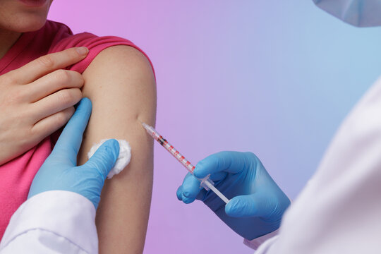 Close-up of a healthcare worker administering a vaccine injection into a patient’s upper arm, symbolizing protection, medical care, and immunization against viruses.