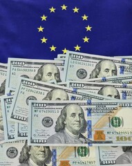 Euro flag background with piles of US dollar banknotes the contrast between European and American...
