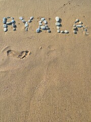 inscription on a sandy beach laid out with stones. inscription Byala. resort town in Bulgaria