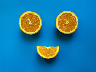 Smile composition made with oranges on blue background, top view