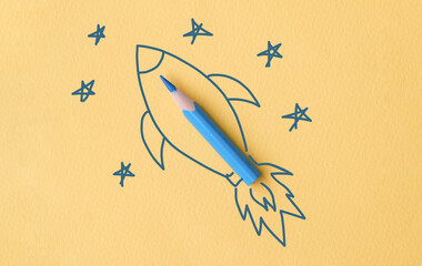 A blue pencil is drawn on a yellow background with a rocket