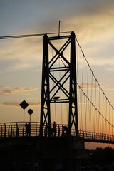 Suspension Bridge Silhouette at Sunset with People on the Side