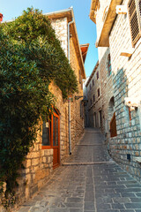 Narrow cobbled street with stone houses in Ulcinj Old Town at sunset, Montenegro