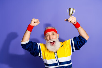 Energetic elderly man celebrating victory with trophy in retro sports attire and vibrant colors...