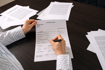 Obraz premium Filling out an application form on the office desk with important paperwork nearby