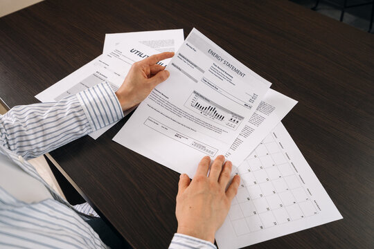 Reviewing utility statement and related documents at a home office desk