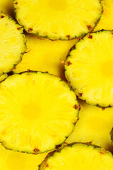 Pineapple juicy yellow slices background. Top view.