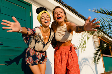 stylish women friends posing on summer tropical vacation