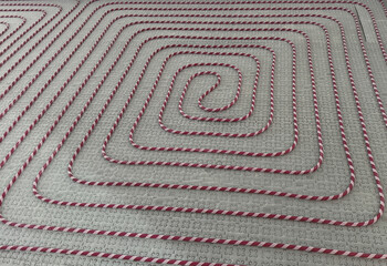 Red and white radiant heating pipes installed on insulated floor panel system