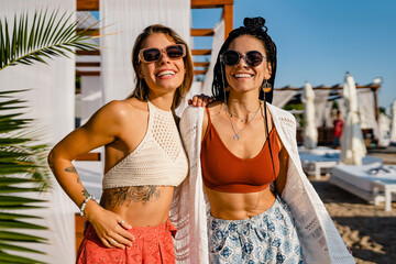 stylish women friends posing on summer tropical vacation fashion style