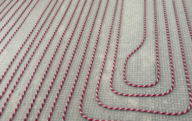 Red and white radiant heating pipes installed on insulated floor panel system