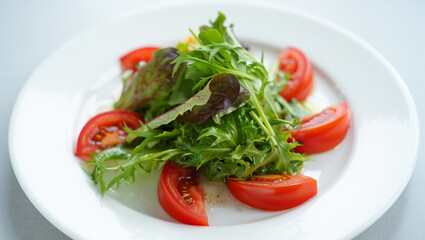 Fresh Red Tomato and Mixed Green Salad on White Plate Simple Food Photography Vibrant Colors Healthy Eating Concept