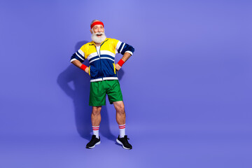 Funny gentleman in colorful retro sportswear poses confidently in vibrant studio, embodying active lifestyle, humor