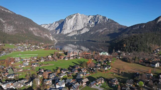 Aerial view of Altausseer See and village surrounded by mountains reflecting in calm alpine waters. Austria, Salzkammergut