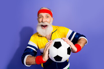 Funky male in retro sportswear holding a soccer ball, exuding joy and energy against a vibrant...
